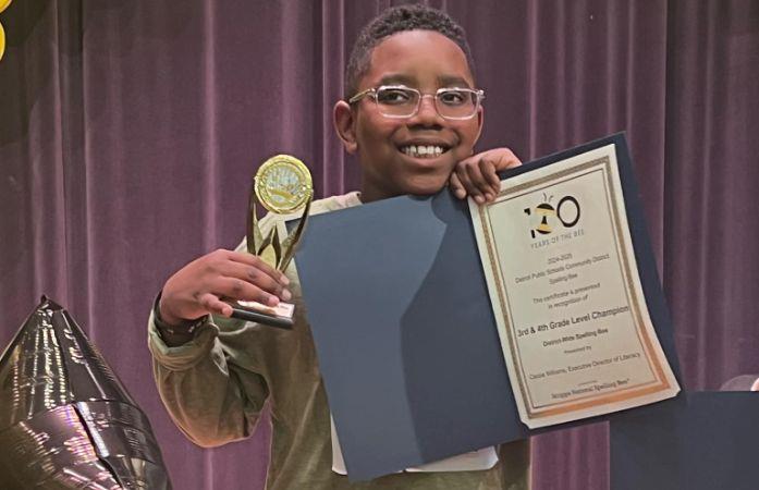 child holding spelling bee trophy